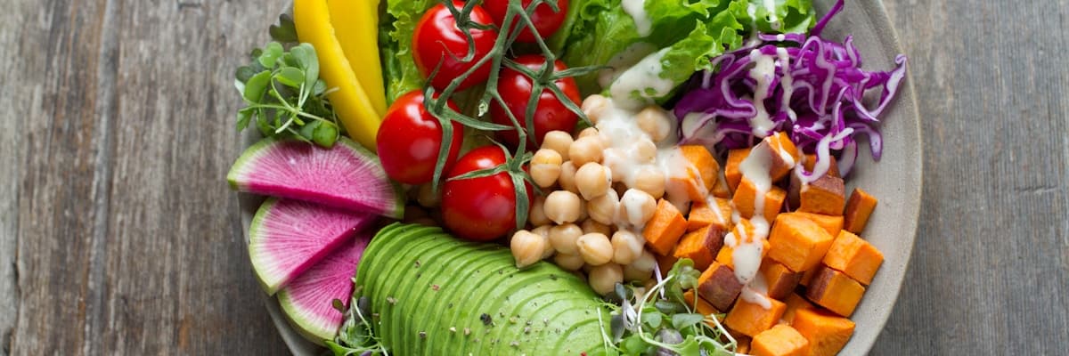 Assiette colorée de légumes frais et graines, représentant un rééquilibrage alimentaire pour adulte